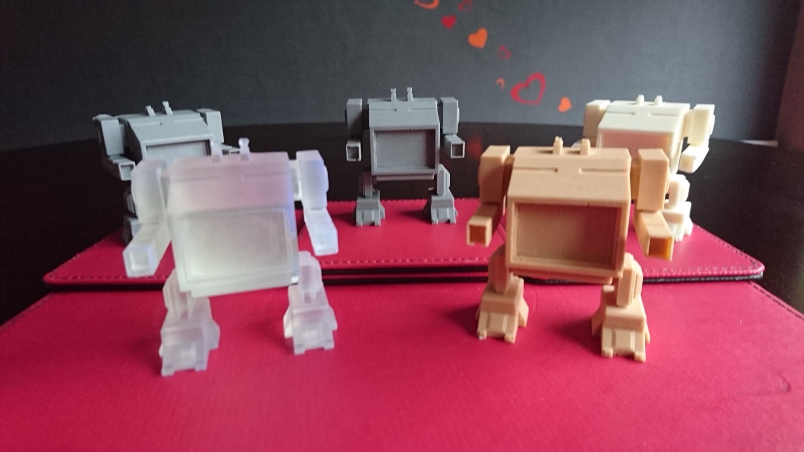 A row of small 3D-printed mecha-style chibi figurines.