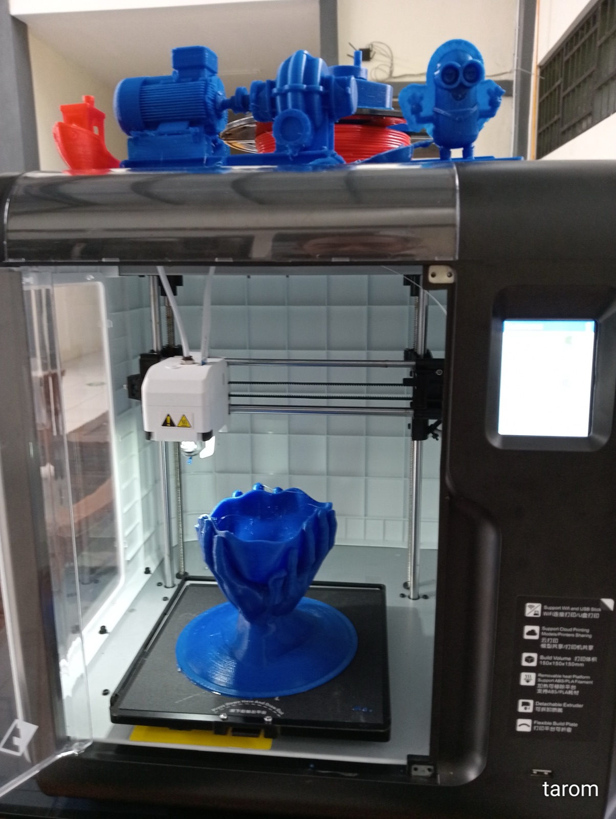 A 3D printer mid-print, extruder head laying down a fresh layer.
